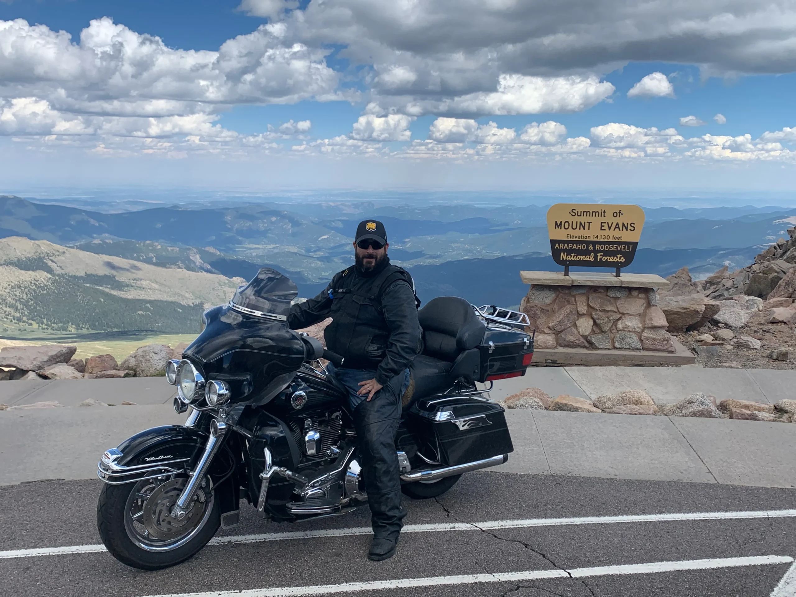 Daniel on his motorcycle at the summit of Mt. Blue Sky